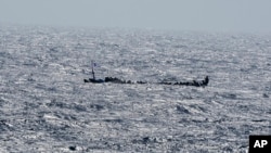 FILE - Migrants crowd a wooden boat near the Canary island of El Hierro, Spain, Aug. 18, 2024.