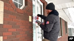 Drew Klein, a senior adviser with AFP Action, a group that has endorsed Nikki Haley, knocks on doors, Jan. 13, 2024, in Urbandale, Iowa.