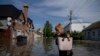 Місцева мешканка в затопленому районі після підриву Каховської ГЕС (AP Photo/Evgeniy Maloletka)