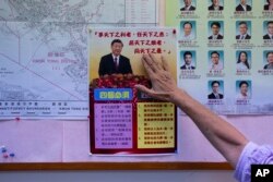 District councllor Winnie Poon presents a poster showing Chinese President Xi Jinping at her office during an interview with The Associated Press in Hong Kong, Nov. 29, 2023.