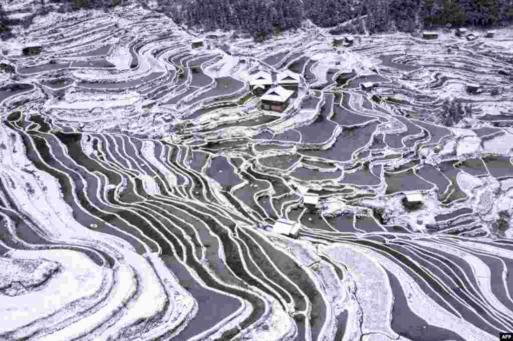 The aerial view shows snow-covered terraced fields and houses in Congjiang county, in China&#39;s southwestern Guizhou province.