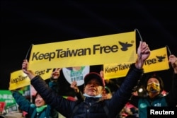 People hold banners as supporters attend a campaign rally of the ruling Democratic Progressive Party (DPP) ahead of the presidential and parliamentary elections in Taipei, Taiwan January 11, 2024. (REUTERS/Carlos Garcia Rawlins)