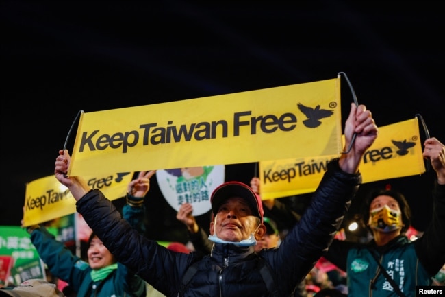 People hold banners as supporters attend a campaign rally of the ruling Democratic Progressive Party (DPP) ahead of the presidential and parliamentary elections in Taipei, Taiwan January 11, 2024. (REUTERS/Carlos Garcia Rawlins)
