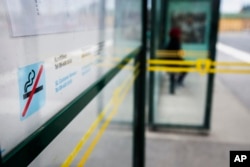 FILE - A no smoking sign is seen at a bus stop in Stockholm, Sweden, June 25, 2019.