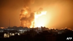 Fire and smoke rise above buildings during an Israeli air strike in Gaza City on Oct. 8, 2023. 