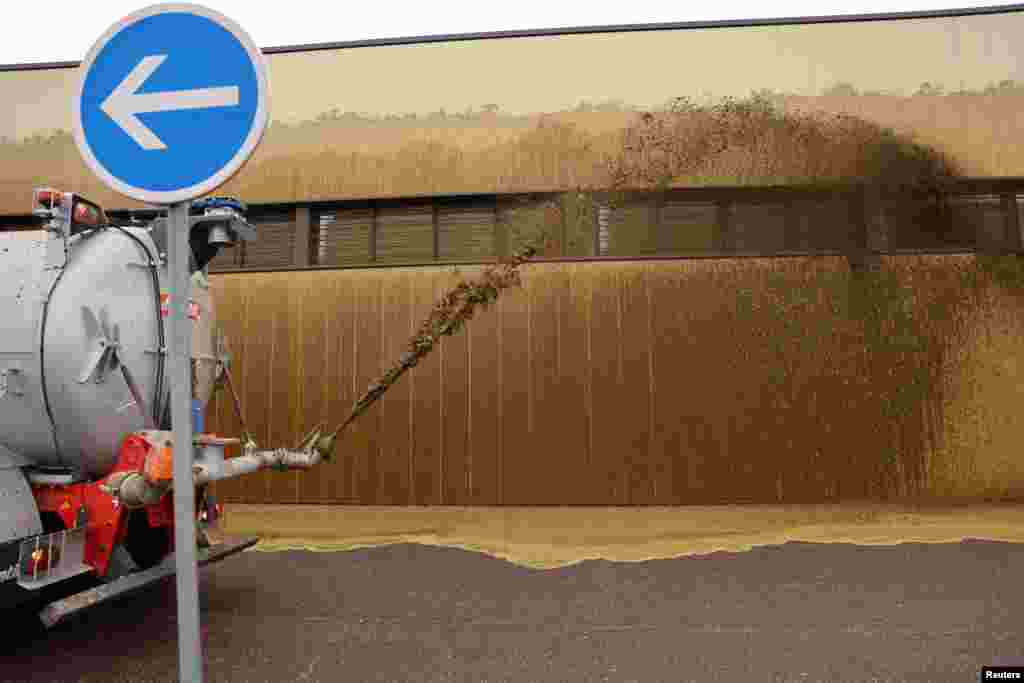 French farmers spray a supermarket with slurry during their protest over price pressures, taxes, green regulation, and grievances shared by farmers across Europe, in Bon-Encontre near Agen, south of France.