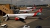 Les avions de Kenya Airways sont vus à travers une fenêtre alors que l'aéroport international de Jomo Kenyatta rouvre après que les vols ont été suspendus à la suite de l'épidémie de la maladie de Coronavirus (Covid-19) à Nairobi, Kenya le 1er août 2020. (Reuters / Njeri Mwangi)