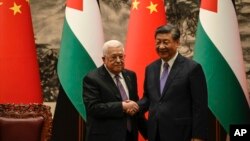 China's President Xi Jinping, right, and Palestinian President Mahmoud Abbas shake hands after a signing ceremony at the Great Hall of the People in Beijing, June 14, 2023.
