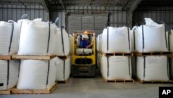 FILE - A worker moves bags of lithium carbonate at an Albemarle Corp. facility, Oct. 6, 2022, in Silver Peak, Nev. The North Carolina company will pay millions to settle foreign bribery allegations, the U.S. Justice Department said Sept. 29, 2023.