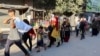 Displaced Palestinians flee an area amid new evacuation orders by the Israeli army, in Deir al-Balah in the central Gaza Strip, Aug. 25, 2024. 