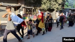 Displaced Palestinians flee an area amid new evacuation orders by the Israeli army, in Deir al-Balah in the central Gaza Strip, Aug. 25, 2024. 