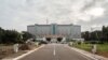 FILE - People drive their car past the Ghana's Parliament during a welcome ceremony for a US congressional delegation in Accra, July 31, 2019.