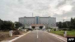 FILE - People drive their car past the Ghana's Parliament during a welcome ceremony for a US congressional delegation in Accra, July 31, 2019.