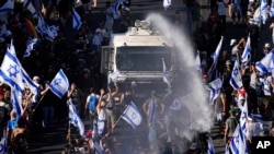 Israeli police use a water cannon to disperse demonstrators blocking a road during a protest against plans by Prime Minister Benjamin Netanyahu's government to overhaul the judicial system, in Jerusalem, July 24, 2023.