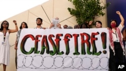 Demonstrators call for a cease-fire in the Israel-Hamas war at the COP28 UN Climate Summit, Dec. 3, 2023, in Dubai, United Arab Emirates. 