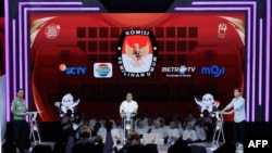 Tiga Cawapres RI: Muhaimin Iskandar (tengah), Gibran Rakabuming Raka (kanan) dan Mahfud MD, dalam debat terakhir pemilihan wakil presiden di Jakarta Convention Center (JCC) di Jakarta, 21 Januari 2024. (Yasuyoshi CHIBA / AFP)