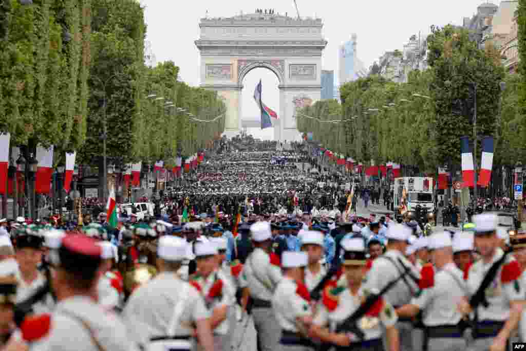 French troops prepare for the Bastille Day military parade on the Champs-Elysees avenue, with the Arc de Triomphe seen in the background, in Paris.