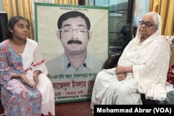 Hazera Khatun, right, with photo of son Sajedul Islam Sumon and Sumon's daughter, Arwa Islam, left, June 17, 2023. Sumon was allegedly abducted by uniformed men from RAB, Dhaka, Bangladesh in 2013.