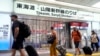 Travelers walk past the closed gate for Tokaido and Sanyo Shinkansen lines as all trains toward to Nagoya or westward are suspended due to heavy rainfall caused by Typhoon Shanshan at the Tokyo Station, Aug. 30, 2024, in Tokyo.