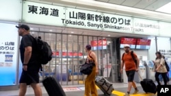 Travelers walk past the closed gate for Tokaido and Sanyo Shinkansen lines as all trains toward to Nagoya or westward are suspended due to heavy rainfall caused by Typhoon Shanshan at the Tokyo Station, Aug. 30, 2024, in Tokyo.