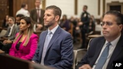 Eric Trump, center, son of former President Donald Trump, is seated ahead of his second day of testimony at New York State Supreme Court, Nov. 3, 2023, in New York. 