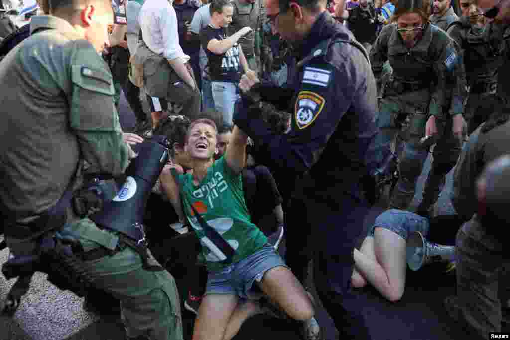 Israel security forces move a person attending a demonstration calling for the immediate return of hostages held in Gaza, outside Prime Minister office in Jerusalem.