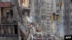 Rescuers clear debris from a multi-story building heavily damaged following a drone strike, in Odesa on March 3, 2024, amid the Russian invasion of Ukraine.