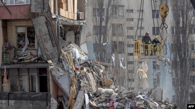 Rescuers clear debris from a multi-story building heavily damaged following a drone strike, in Odesa on March 3, 2024, amid the Russian invasion of Ukraine.
