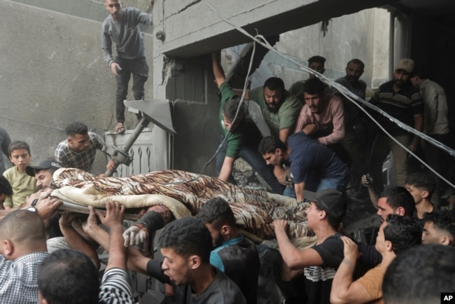 Palestinians carry a body found under the rubble of a destroyed house following an Israeli airstrike in Khan Younis refugee camp, southern Gaza Strip, Nov. 18, 2023.