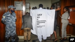 FILE - An Ugandan lawmaker wears clothing with an anti-LGBTQ message as he enters the Parliament building to vote on a harsh new anti-gay bill, in Kampala, March 21, 2023. Uganda's President Yoweri Museveni signed the bill into law on May 29, 2023.