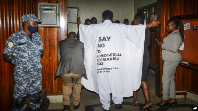 FILE - An Ugandan lawmaker wears clothes with an anti-LGBTQ message as he enters the Parliament building to vote on a harsh new anti-gay bill, in Kampala, March 21, 2023. Uganda's President Yoweri Museveni signed the bill into law on May 29, 2023.