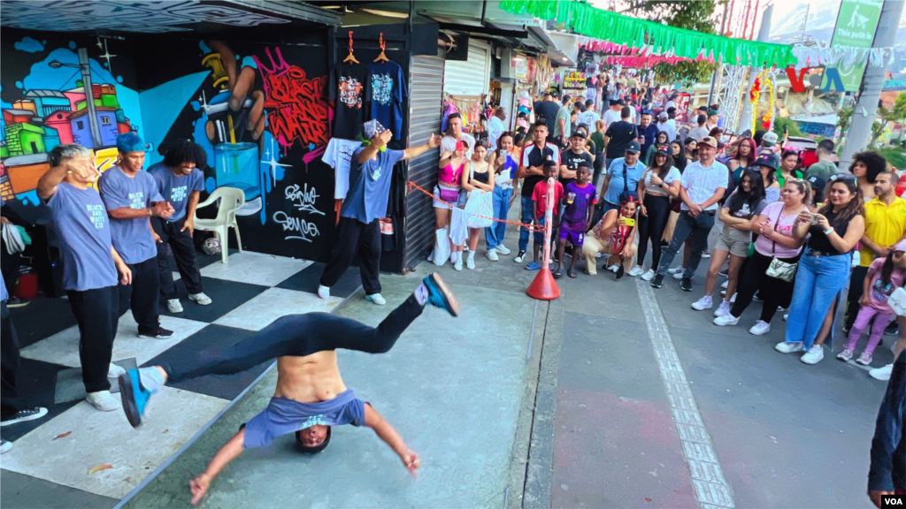 Un artista local baila para turistas y locales que se detienen a fotografiarlo.