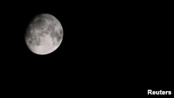 A view of the moon over a mountain in Garmisch-Partenkirchen, Germany, July 19, 2024. (REUTERS/Angelika Warmuth)