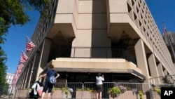 FILE - People take photos of the FBI building headquarters in Washington, Aug. 13, 2022.