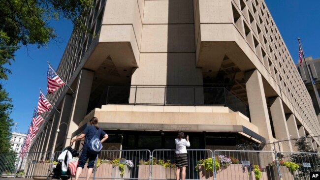FILE - People take photos of the FBI building headquarters in Washington, Aug. 13, 2022.