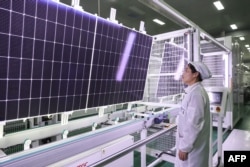 FILE - An employee works on solar photovoltaic modules that will be exported at a factory in Lianyungang, in China's eastern Jiangsu province, Jan. 4, 2024.