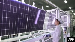 FILE - An employee works on solar photovoltaic modules that will be exported at a factory in Lianyungang, in China's eastern Jiangsu province, Jan. 4, 2024. 