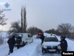 First responders release cars that are stuck in snow during a heavy snowstorm in Mykolaiv region, Ukraine in this picture released Nov. 27, 2023, by the press service of the State Emergency Service of Ukraine. (Handout via Reuters)