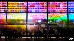 People look at an exhibit of LG Signature OLED T 4K transparent wireless TV's at the LG booth during the CES tech show Tuesday, Jan. 9, 2024, in Las Vegas. (AP Photo/John Locher)