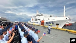 Philippine Coast Guard personnel wave Vietnamese and Filipino flags to welcome the Vietnam Coast Guard (VCG) ship, CSB 8002, in Manila, Aug. 5, 2024.