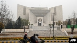 FILE - Commuters ride past the Pakistan's Supreme Court building in Islamabad, Jan. 12, 2024.