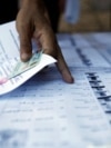 FILE - People search for their names on a voting list during local elections in Phnom Penh, Cambodia June 4, 2017. 