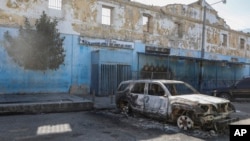 A burned car is seen outside the National Penitentiary in downtown Port-au-Prince, Haiti, March 3, 2024.
