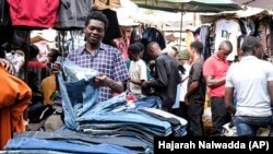 Vendedor de roupa usada no Mercado Owino em Kampala, capital de Uganda.