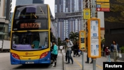 Orang-orang mengantre untuk naik bus tingkat di Hong Kong, China, 27 Februari 2024. (Foto: REUTERS/Tyrone Siu)