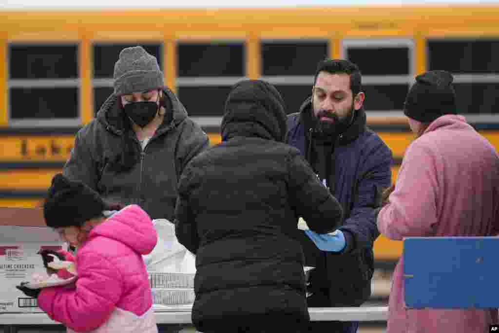 Faraz Sardharia, a la derecha, y Heather Nichols, de la organización sin fines de lucro Chi-Care, sirven alimentos a migrantes en Chicago.&nbsp;