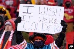 A fan holds up a sign before an NFL wild-card playoff football game between the Kansas City Chiefs and the Miami Dolphins, Jan. 13, 2024, in Kansas City, Missouri.