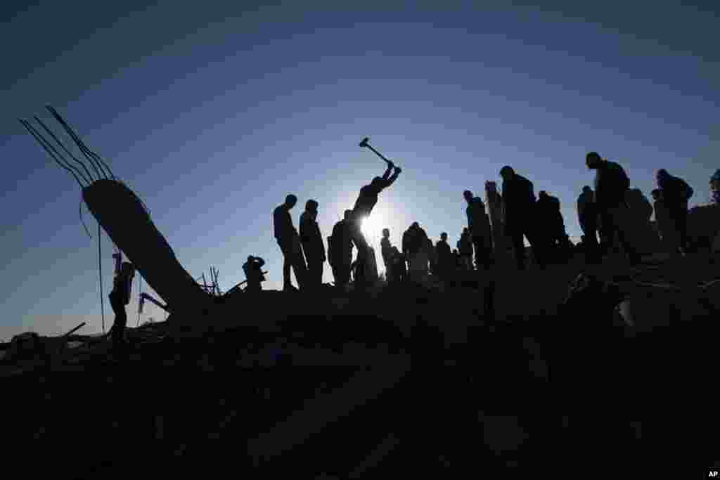 Palestinians search for bodies and survivors in the rubble of a house destroyed in an Israeli airstrike, in Rafah, southern Gaza Strip.