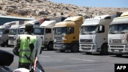 A convoy of trucks carrying humanitarian aid is seen parked after crossing the Syrian Bab al-Hawa border crossing with Turkey, on July 10, 2023. 