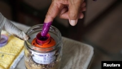 A person dips their finger in ink at a polling station on the day of Cambodia's general election, in Phnom Penh, Cambodia, July 23, 2023